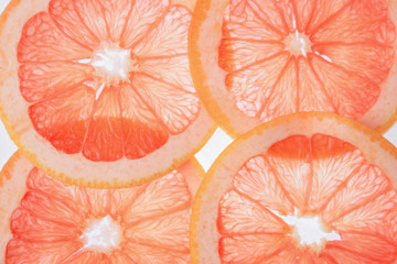 translucent grapefruit slices on a white background, citrus fruit slices
