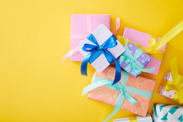 top view of festive colorful gift boxes on yellow background
