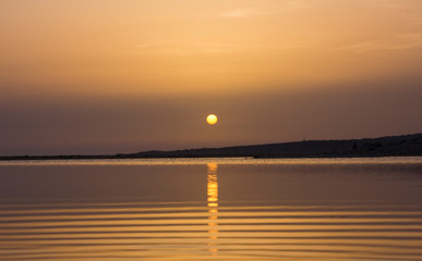 landscape of a sunset in the sea, the sky and the sea are tinged with orange colors