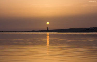landscape of a sunset in the sea, the sky and the sea are tinged with orange colors