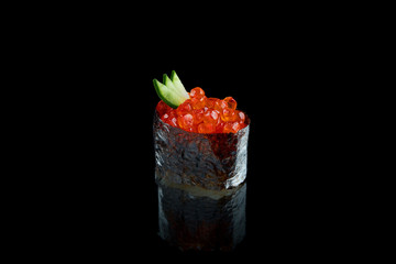 Classic japanese sushi with red caviar on a black background with reflection. Photo for the menu