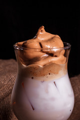 Dalgona coffee cold drink with milk whipped with foam, instant coffee, Korean trend home-made coffee. Close up