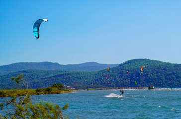 Akyaka, Mugla/Turkey-August 14 2018: Many surfers enjoying kite surfing at the beach where Azmak River meets the Mediterranean Sea
