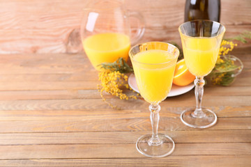 Glasses of tasty mimosa cocktail on wooden table