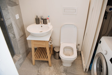 modern bathroom with toilet, washbasin and washing machine