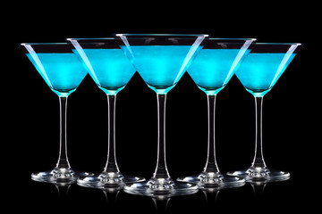 Set of Blue Curacao cocktail in martini glasses isolated on black background