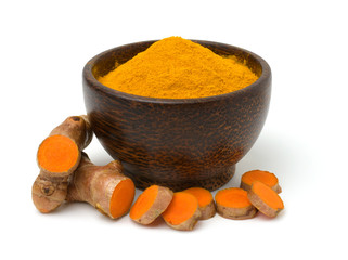 Turmeric (curcumin) powder in a black wooden bowl and fresh turmeric rhizome isolated on a white background.