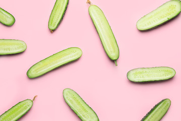 Green cut cucumbers on color background