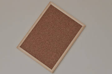 Fototapeta premium Cork board hanging on the wall with wooden frame.
