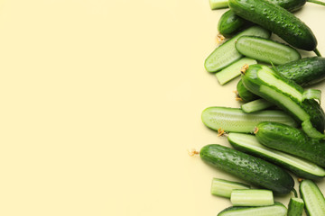 Green cucumbers on color background
