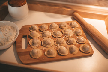 Raw dumpling with meat. Preparation dumplings on a wooden board.