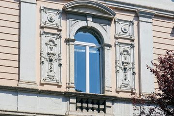 Italian window on the beautiful wall facade with sas-relief on the both sides