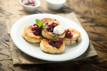 Obraz na płótnie Canvas Homemade cottage cheese cakes with cherry sauce