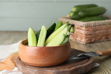 Bowl with green cucumbers on table