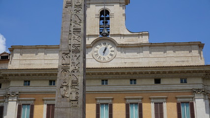 obelisk z zegarem w tle i dzwonem