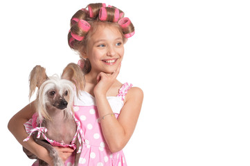 Happy little pretty girl in hair curlers with dog in studio
