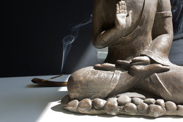 Close up Buddha statue detail with insence stck into sun light hope pray meditation calm down...