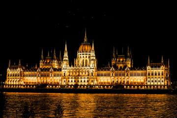 Fototapeta na wymiar Hungarian Parliament building and Danube River in the Budapest city at night. A sample of neogothic architecture, Budapest's tourist attraction