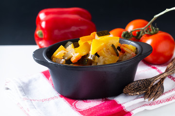 Food concept Homemade French organic Ratatouille in white bake ceramic bowl on blask slate stone board © TYSB