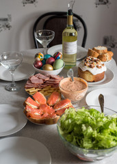 Easter festive table with traditional Easter food and drinks. Colored eggs, Easter cake, wine and other treats on the festive table