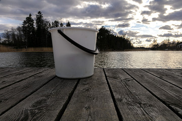 White bucket for fishing on the background of the river © M.V.schiuma