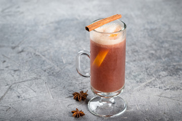 Mulled wine in a glass, tall, transparent glass with cinnamon and lemon