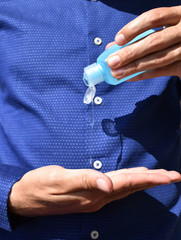 Business man wiping his hands with a transparent disinfectant gel, virus, contamination, covid-19