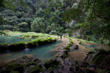 Fototapeta na wymiar Paradise remote jungle waterfalls of semuc champey fresh turquoise clear water lush green rainforest