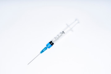 Isolated syringe with blue liquid on white background