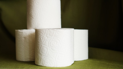 Toilet paper is consider a must item during crisis. Tissue rolls on dark green background for copyspace