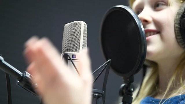 Regording studio. Child girl singing or role voicing