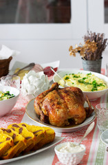 Homemade holiday dinner with baked chicken, mashed potatoes, salad, snacks and dessert.