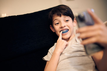 boy shows myofunctional trainer. Helps equalize the growing teeth and correct bite, develop mouth breathing habit. Corrects the position of the tongue.