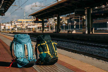 Two Hiking backpacks of different colors and excellent quality were photographed at the railway station | PADUA, ITALY - 29 JULY 2019.