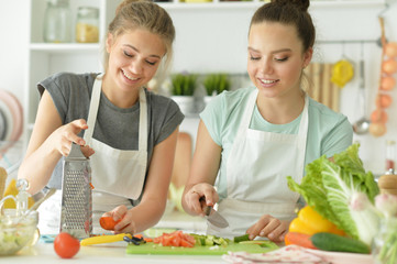 Portrait of beautiful teenagers cooking in kitchen
