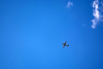 dark silhouette of airplane flying over the blue skies