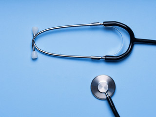Modern stethoscope with one-sided head chestpiece with diaphragm on a Blue stethoscope for doctor diagnostic coronavirus disease, medical tool for health on black background with copy space. 