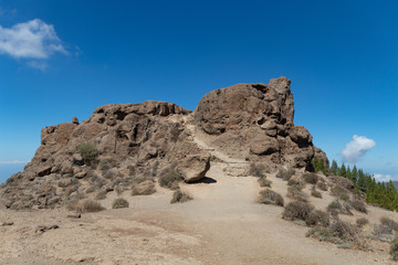 Fototapeta na wymiar Monumento de roca natural con camino y bajo cielo azul