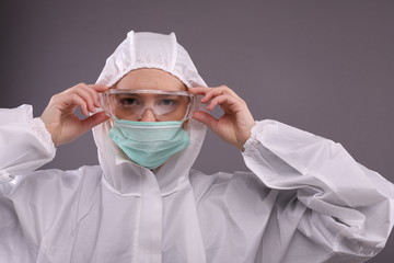 Close up of a woman in protective costume putting on a mask