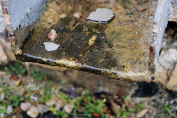 Gutter. Drop of water. Drop of water drops from a metal surface drop of water. Drain in Kenya