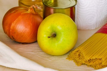 Close-up of grocery products: canned food, pasta, vegetable oil, vegetables, fruit. The purchase of food.