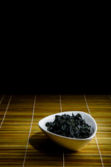 Wakame dried inside chawan, oriental composition. Seaweed used in Japanese cuisine. It is present in Japanese dishes. It is widely used as an ingredient in miso soup and sunomono,
