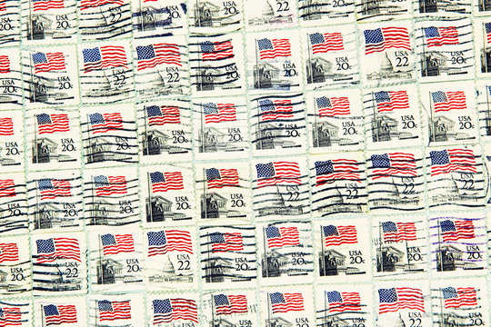 USA postage stamps with USA flag as background.