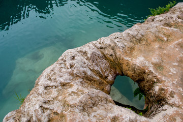 formaciones por el agua de piedra blanca caliza con laguna de agua turquesa y cuevas acuáticas en...