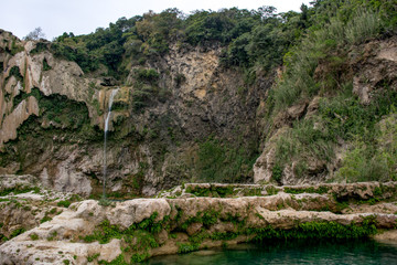 Montaña con caída de agua y formaciones de la roca caliza en pozas y cuevas subterráneas debajo del agua turquesa en la selva de México en la Huasteca Potosina en San Luis Potosí 