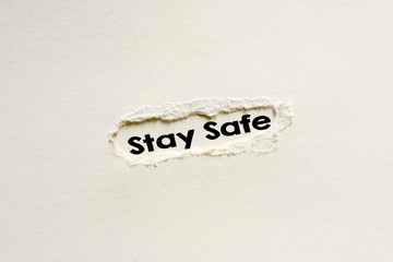 STAY SAFE word written on a white sheet. View from above.