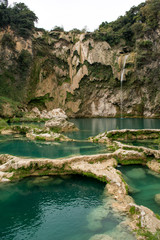 Toma vertical de la cascada el salto con poca agua cayendo y las pozas de agua turquesa  descubiertas y llenas de agua en México en la Huasteca Potosina en San Luis Potosí
