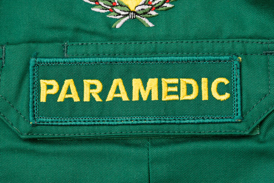 Kent, UK. 11th April 2020.  Close up view of a British PARAMEDIC badge sewn onto green paramedic shirt.