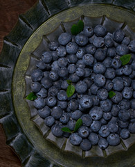 Fresh blueberries background in retro metal plates.  Vegan and vegetarian concept. Macro texture of blueberry berries. Summer healthy food.