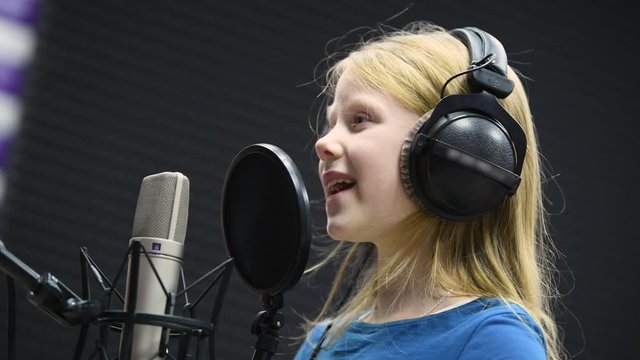 Regording studio. Child girl singing or role voicing